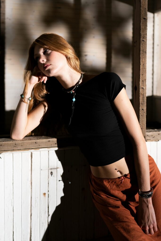 A fashionable woman posing thoughtfully in stylish attire, showcasing elegance.